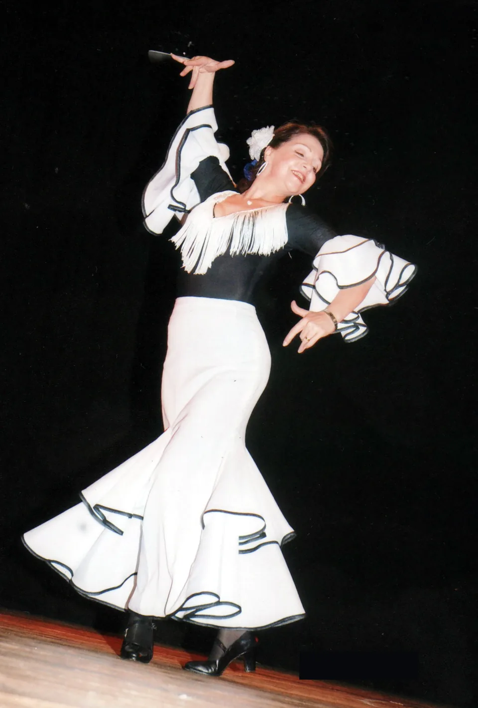 Teresita Sesmero interpretando danza española con traje blanco y negro